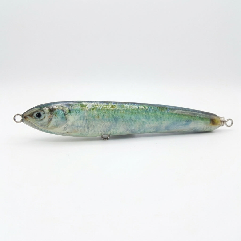 Blueback herring pattern JigSkinz lure skin on a topwater stickbait, side view on dark countertop