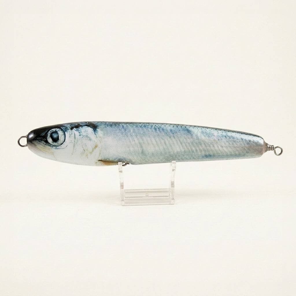 Herring pattern JigSkinz lure skin on a saltwater stickbait, displayed on clear stand against dark background