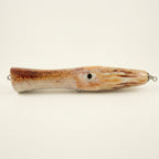 Squid pattern JigSkinz lure skin on a topwater squid popper, side view on dark granite