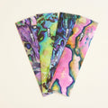 JigSkinz abalone lure skin sheets fanned out in four shell color patterns on dark granite
