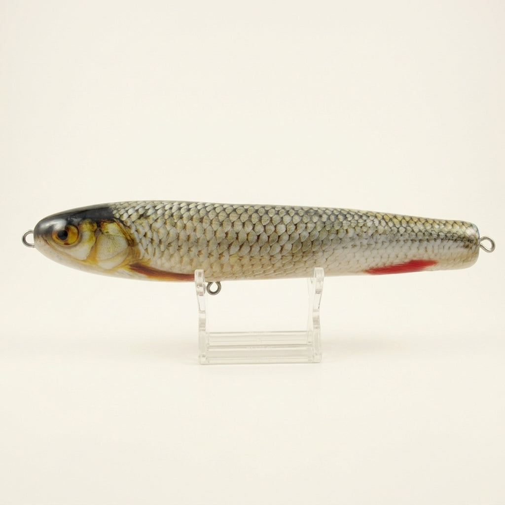 Roach pattern JigSkinz lure skin on a stickbait, on clear stand outdoors with green foliage behind